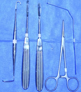 Figure 5 Instruments used in chin implant placement are (from left to right): a blunt Senn skin retractor, a 6 mm periosteal elevator, an 8 mm periosteal elevator, two straight Kelly clamps (only one is shown in image), and an 8 mm ribbon retractor